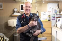 Le Dr Jean Marc Denoun avec un chat noir dans les bras